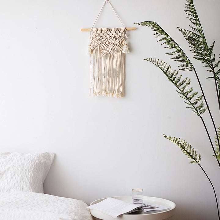 Handmade macrame wall hanging with long tassels and wooden rod