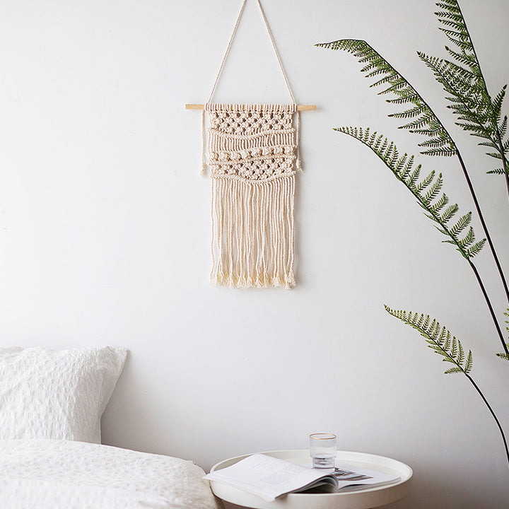 Handmade macrame wall hanging with long tassels and wooden rod