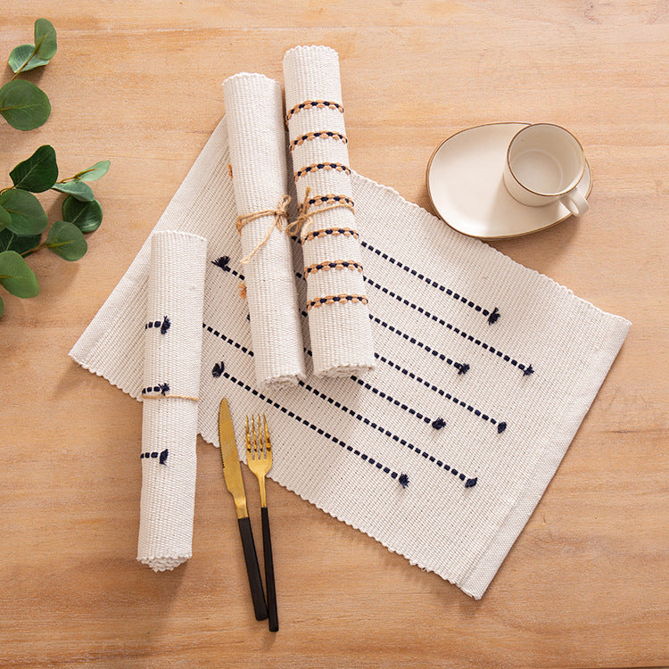 Woven placemats and table runners made of cotton blend with fine dot stripes and knot applications Kalsten