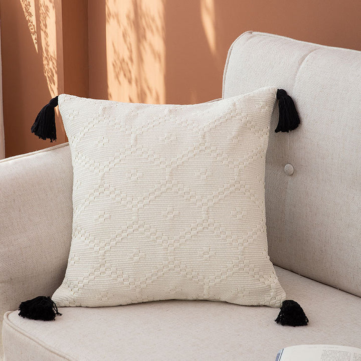 Decorative cushion cover made of woven cotton blend with tactile diamond structure and contrast tassels