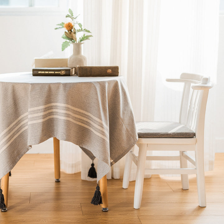 Rectangular linen look tablecloth with fringed tassels and side stripe border design Kalsten