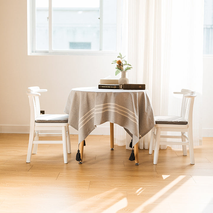 Rectangular linen look tablecloth with fringed tassels and side stripe border design Kalsten