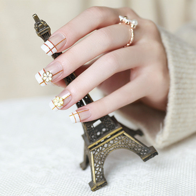 Artificial nails with elegant 3D flower accents and gold trim Kalsten