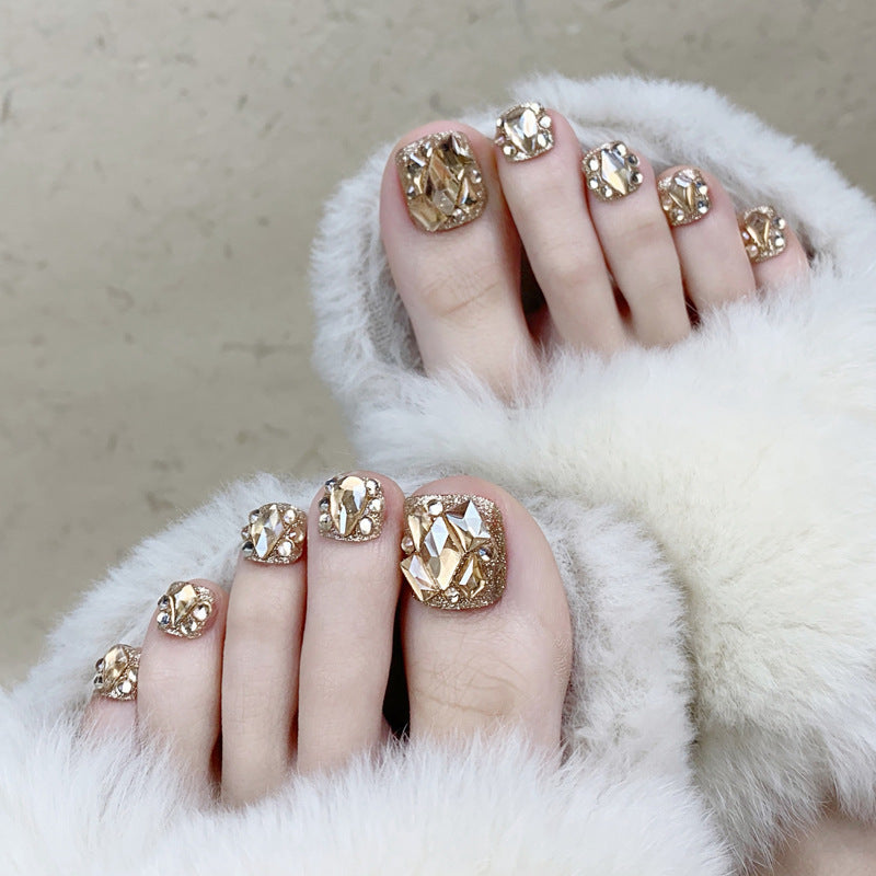 Artistic toenail art with rhinestone and glitter elements Kalsten