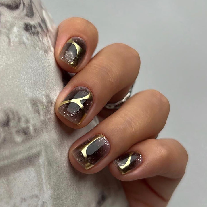 Artificial nail art with elegant metallic design and glitter accents Kalsten