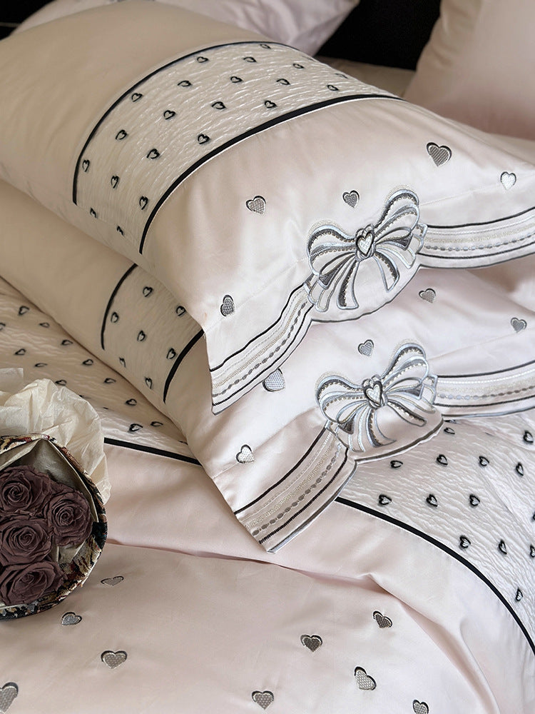 Romantic cotton satin bedding set with embroidered ribbon borders and decorative pillow