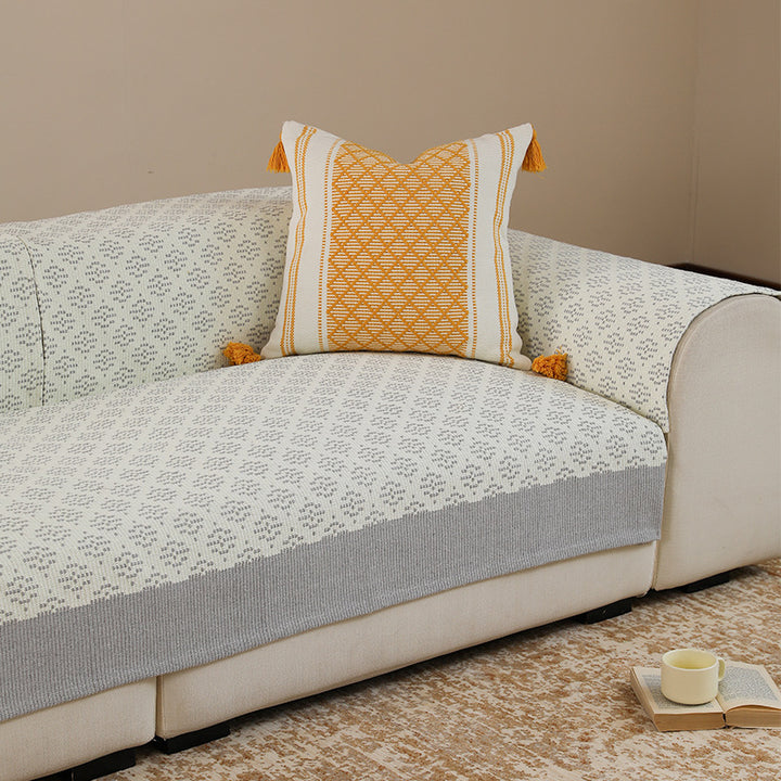 Knitted sofa cover with jacquard pattern and reinforced hem border Kalsten