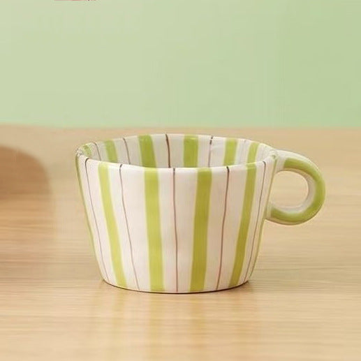 Ceramic coffee mug with ergonomic round handle and fine striped texture