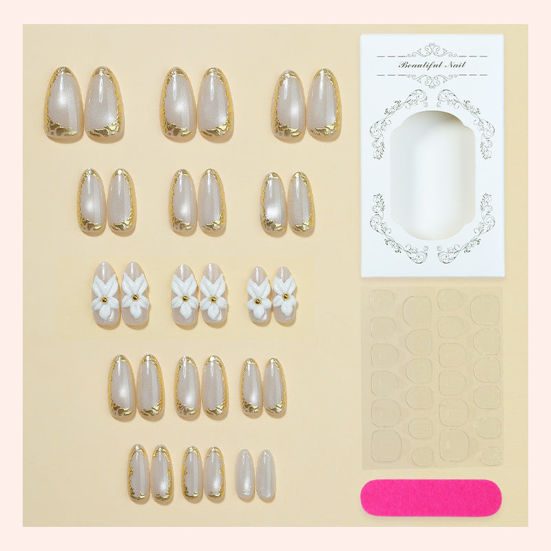 Acrylic nail set with elegant gold embellishments and floral accent Kalsten