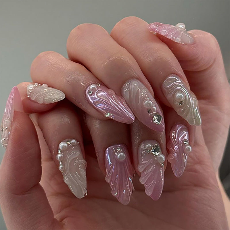 Artificial nail art with elegant swirl design and pearl embellishments Kalsten