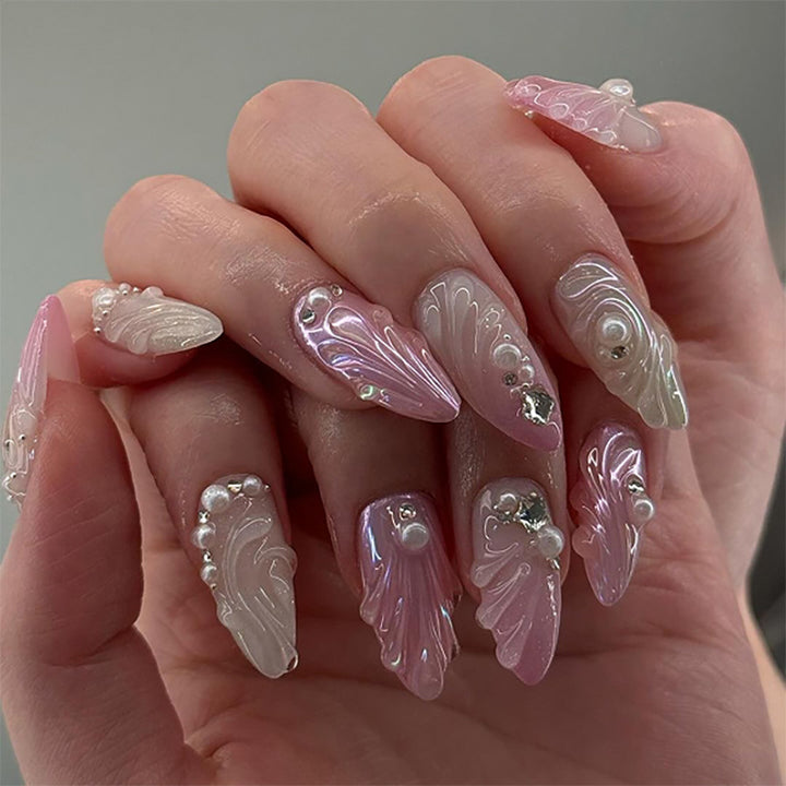 Artificial nail art with elegant swirl design and pearl embellishments Kalsten