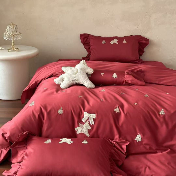 Festive satin bedding set with embroidered pine and mythical creature appliqués and ruffled cushion