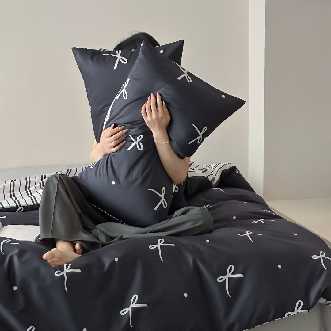 Modern cotton bedding set with minimal bow print and striped reversible side