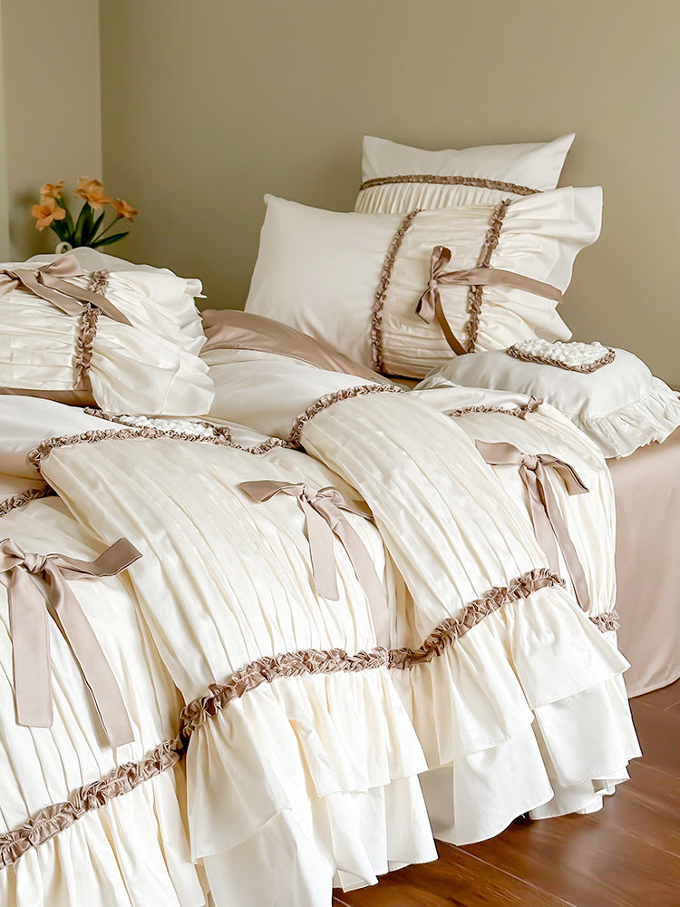 Pleated bed linen set with ruffle, decorative ribbons and bow accents