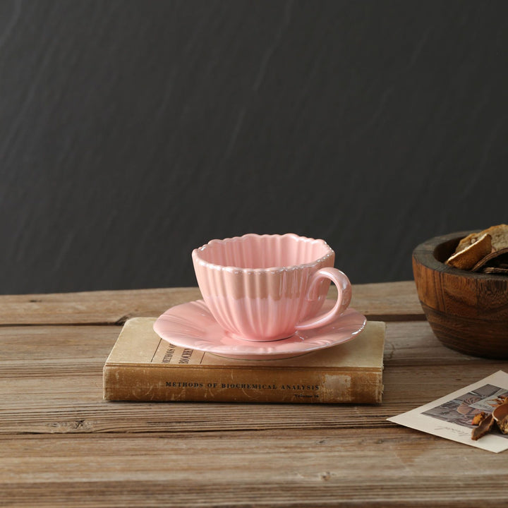 Fine porcelain tea cup with ribbed shell shape and matching saucer