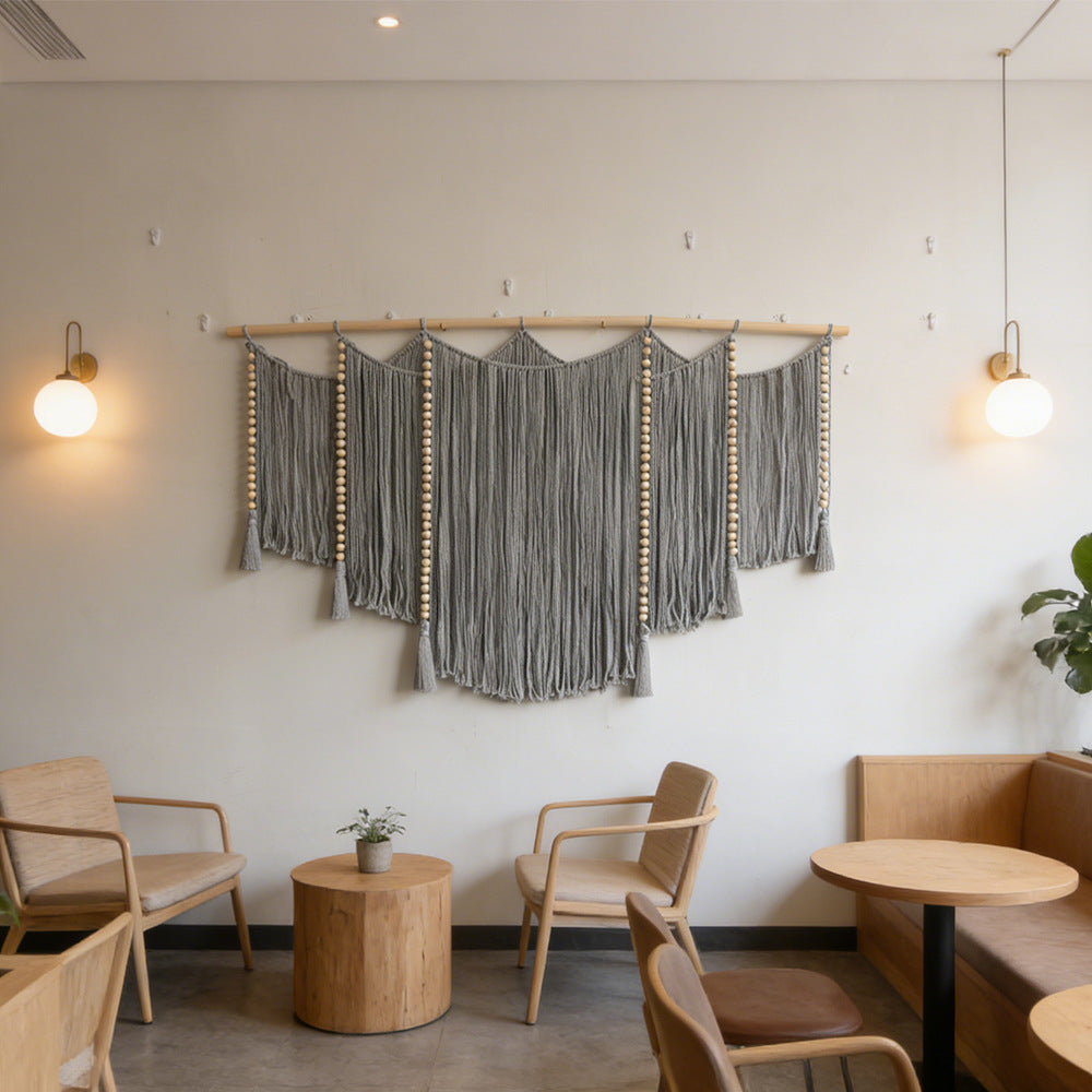 Macramé wall hanging with intricate fringes and wooden beads