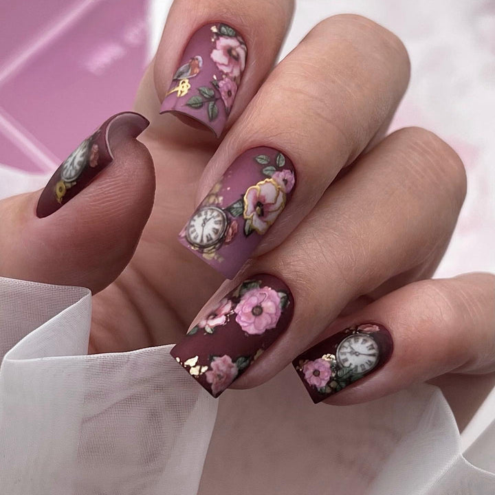 Nail art with floral design and intricate clock motifs Kalsten