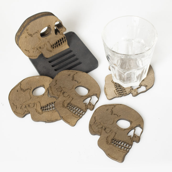 Set of laser-engraved wooden coasters in skull shape with storage stand