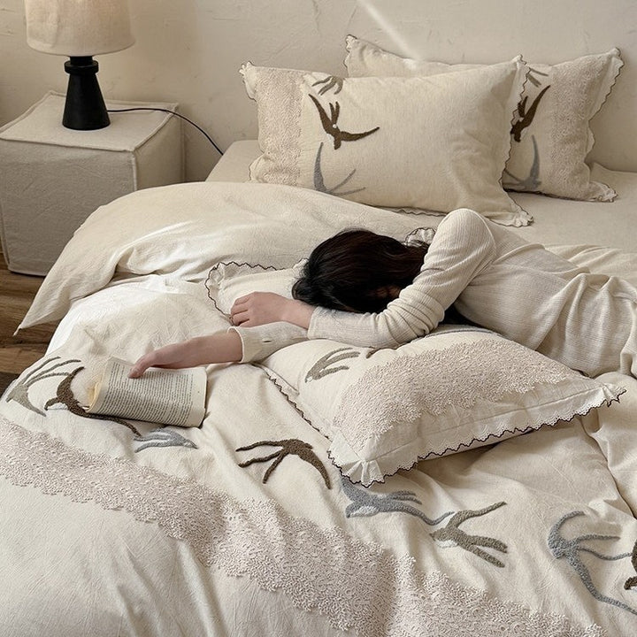 High-quality bedding set with embroidered swallows, lace trim and linen look
