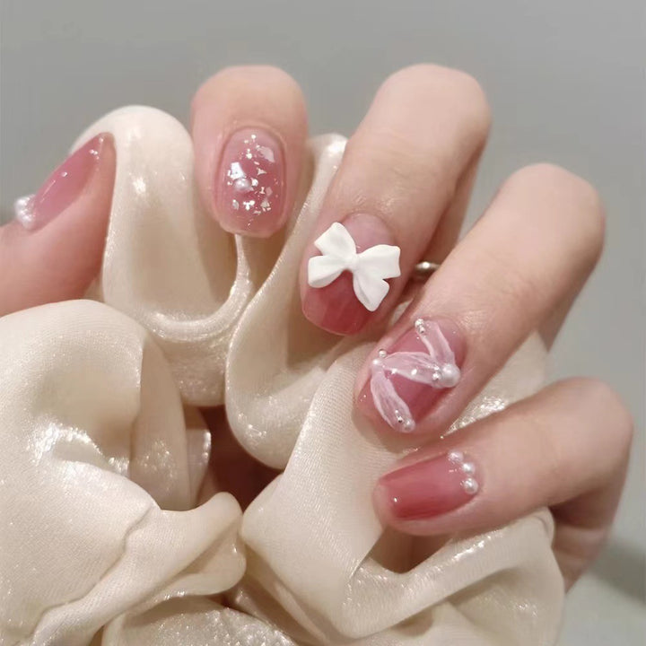 Glamorous nail art with pearl and bow accents Kalsten