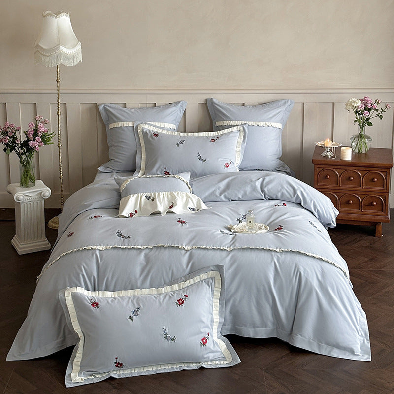 Duvet cover set made of premium cotton satin with subtly embroidered wildflower motif and ruffle edge