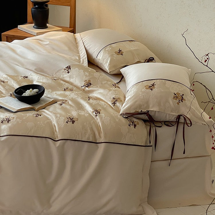 Satin bedding set in jacquard look with floral embroidery details and ribbon ties