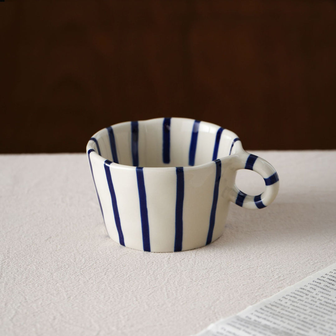 Handmade ceramic mug with ergonomic handle and wavy rim