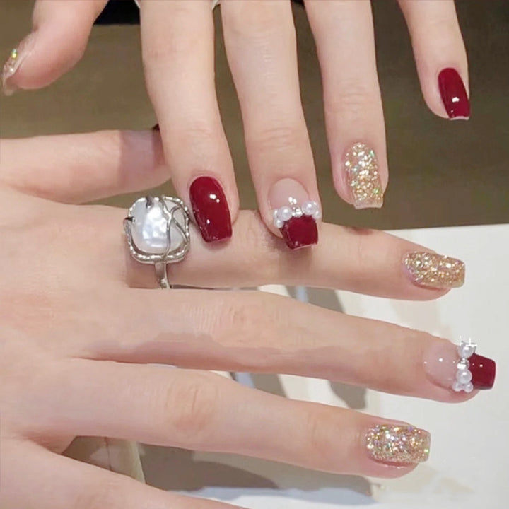 Glamorous artificial nails with glitter and pearl decorations Kalsten