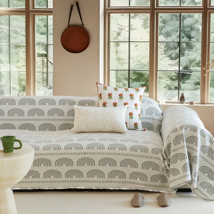 Geometric sofa cover made of cotton blend fabric with decorative fringe edge
