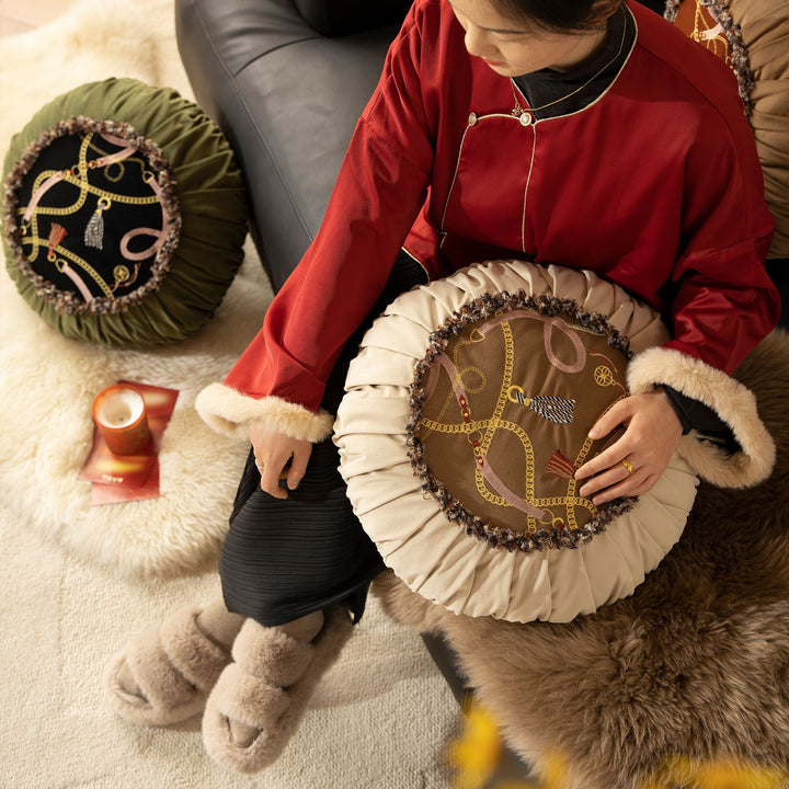Round decorative pillow with pleated edge, fringe trim, and chain tassel motif Kalsten