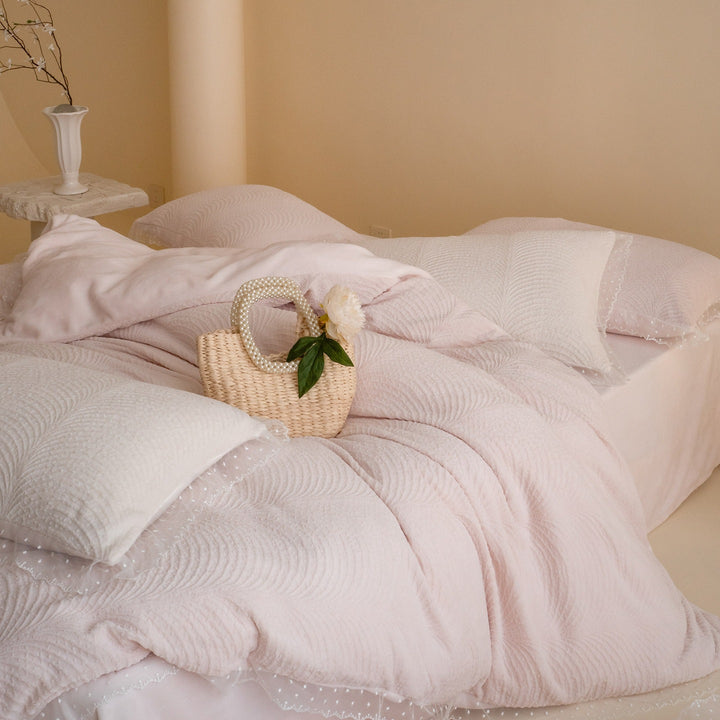 Quilted bedding set with lace edge and wave quilting pattern