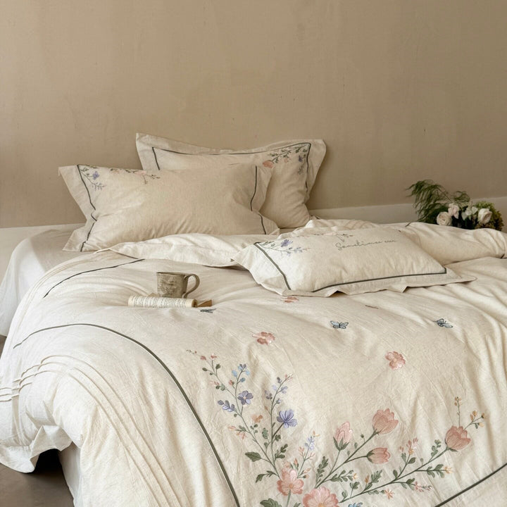 Natural fiber duvet cover set with delicate floral hand embroidery, linen look, and decorative ruffle