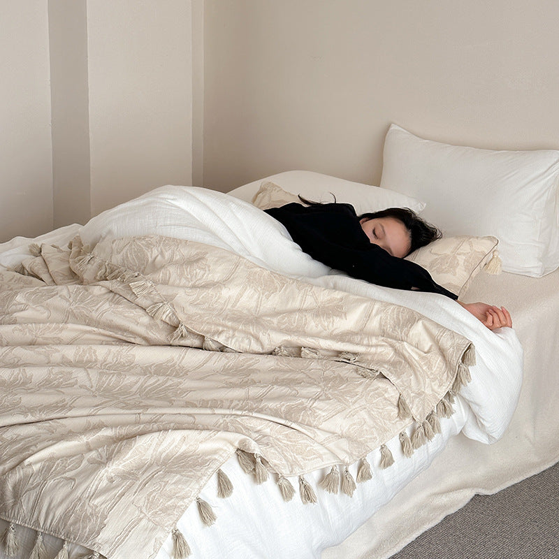 Woven blanket made of cotton blend with decorative tassels