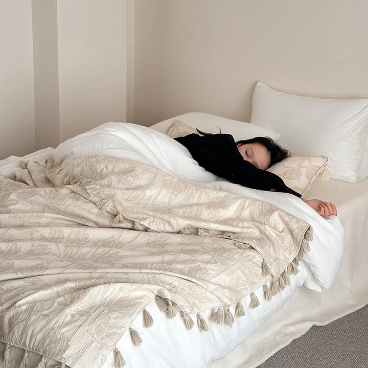 Woven blanket made of cotton blend with decorative tassels