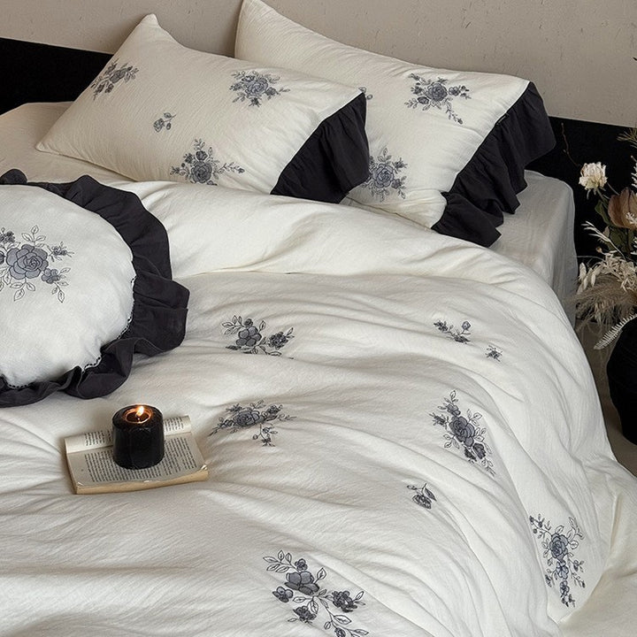 Cotton muslin bedding set with embroidered rose emblems and fine ruffle