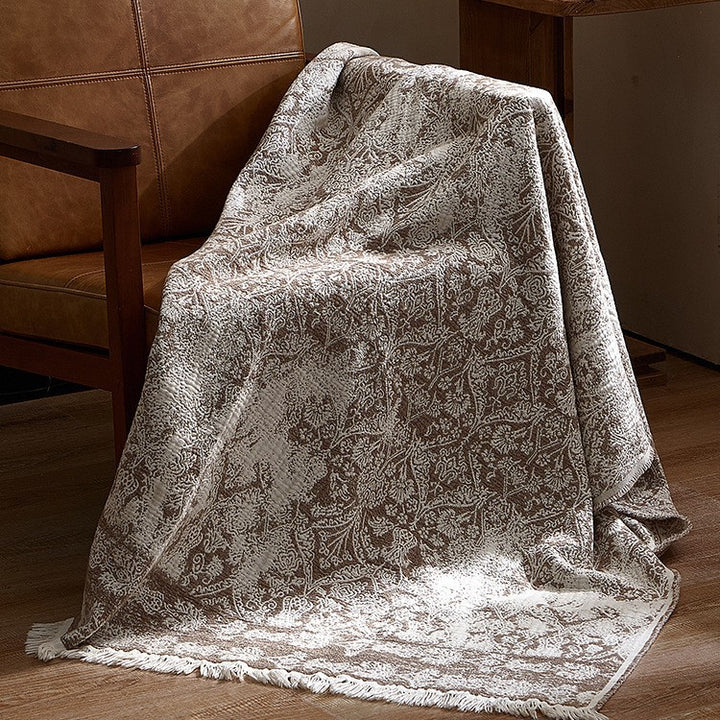 Large cozy living blanket made of cotton blend fabric with geometric jacquard pattern and fringed hem