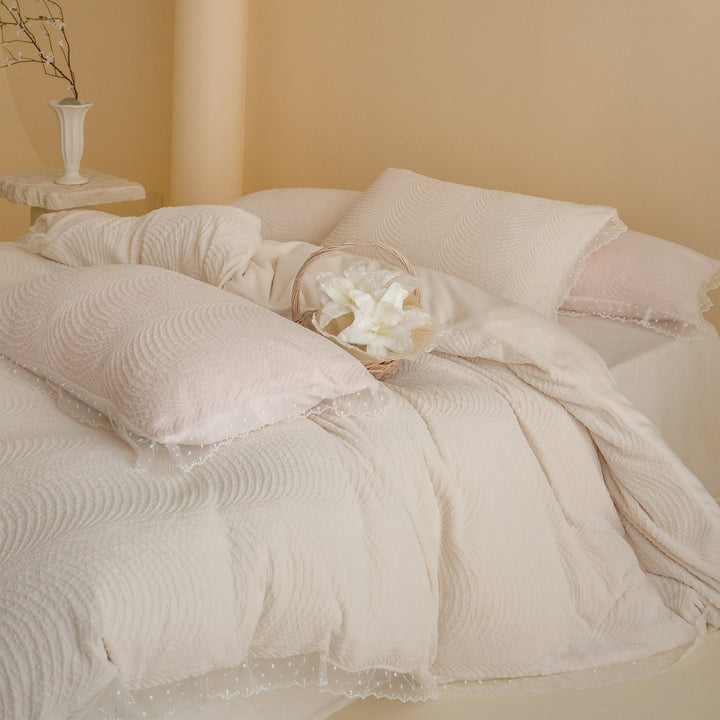 Quilted bedding set with lace edge and wave quilting pattern