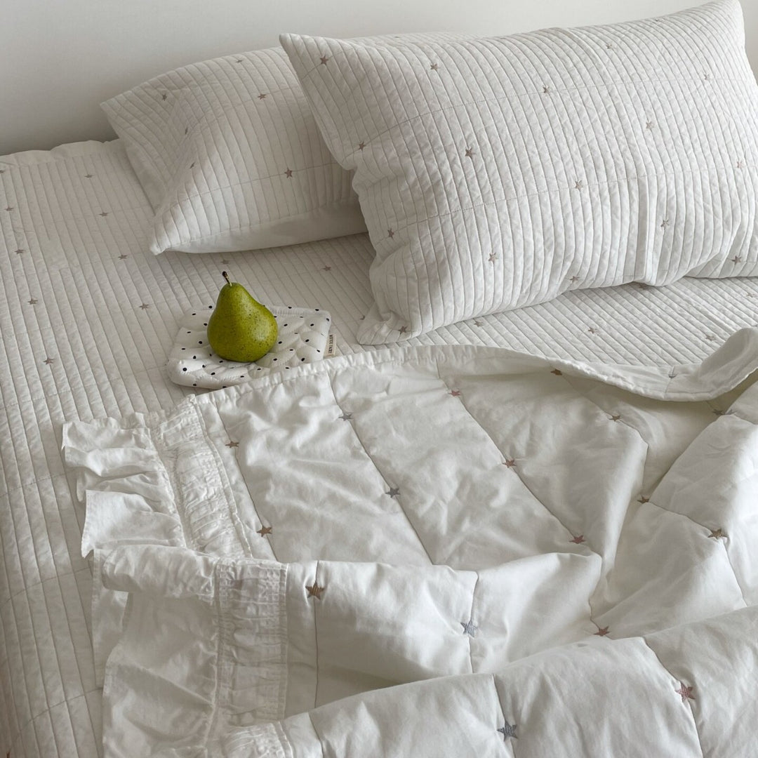 Quilted bedspread with delicate longitudinal stitching and matching pillowcases