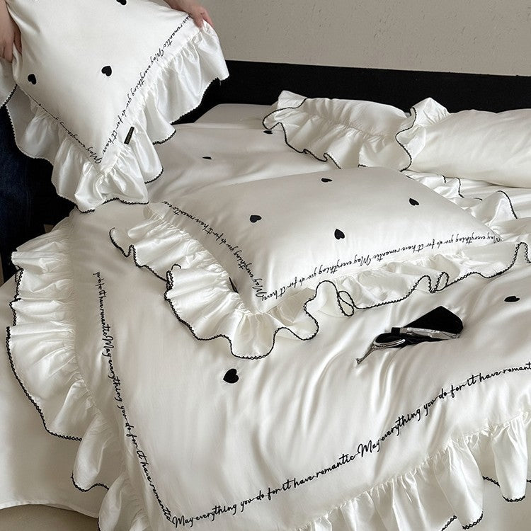 Luxurious cotton satin bedding set with ruffled trim, embroidered heart motifs, and calligraphic writing