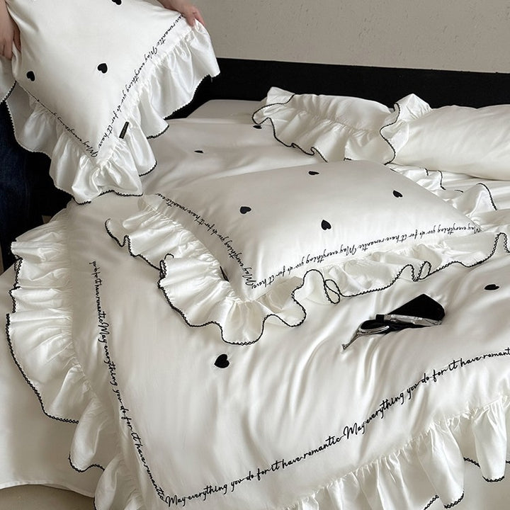 Luxurious cotton satin bedding set with ruffled trim, embroidered heart motifs, and calligraphic writing