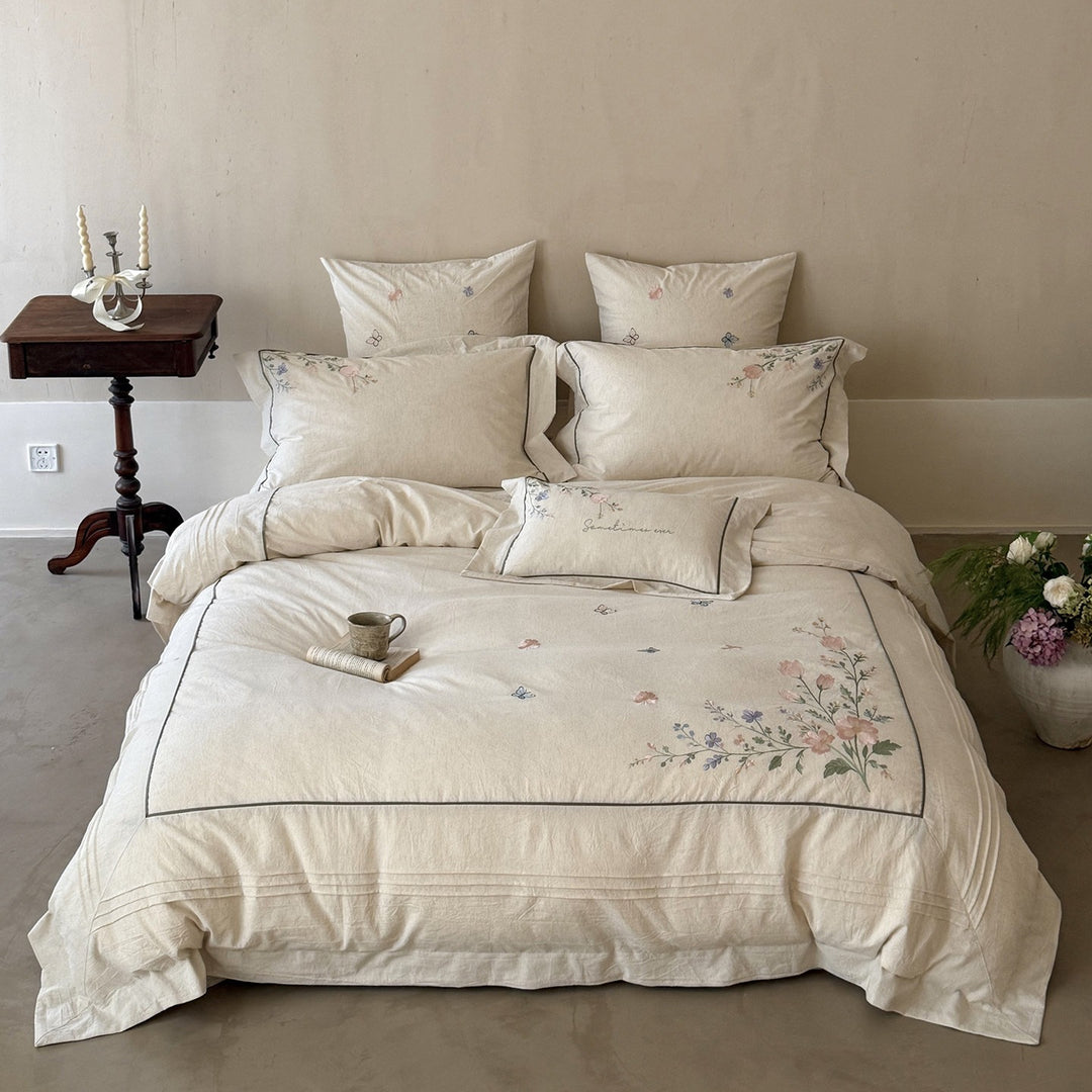 Natural fiber duvet cover set with delicate floral hand embroidery, linen look, and decorative ruffle