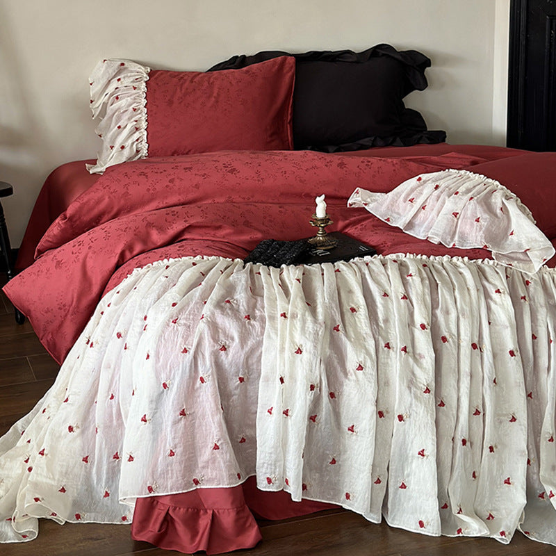 Ruffled bedskirt and pillowcases made of embroidered cotton-linen blend
