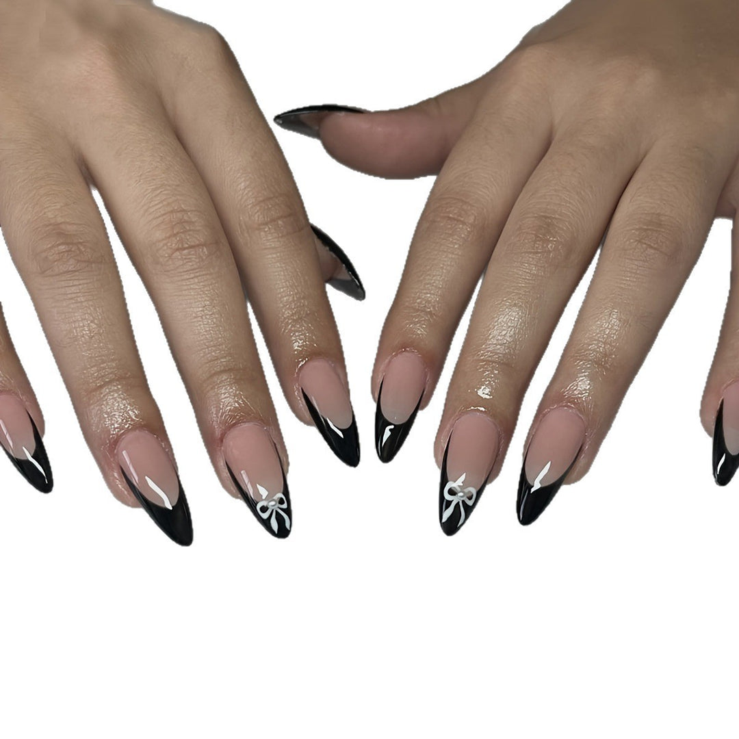 Acrylic nail set with elegant black and white design and cute bow accents Kalsten