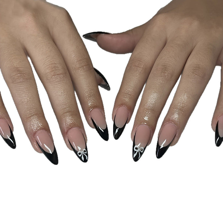 Acrylic nail set with elegant black and white design and cute bow accents Kalsten