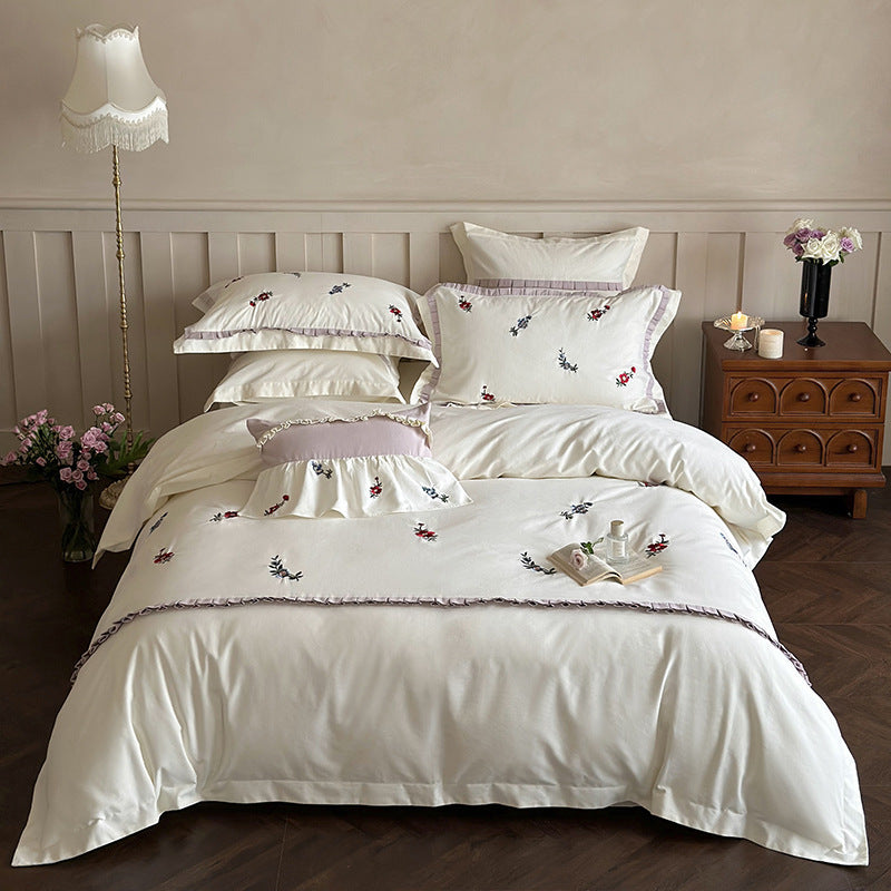 Duvet cover set made of premium cotton satin with subtly embroidered wildflower motif and ruffle edge