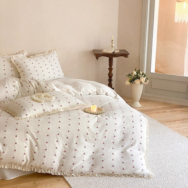 Quilted bedding set made of cotton muslin with delicate cherry print and ruffle edge