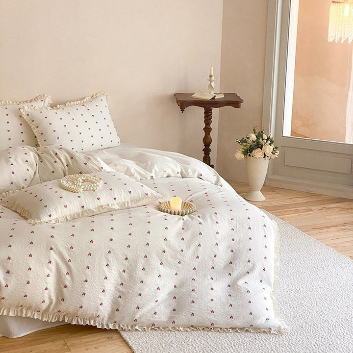 Quilted bedding set made of cotton muslin with delicate cherry print and ruffle edge