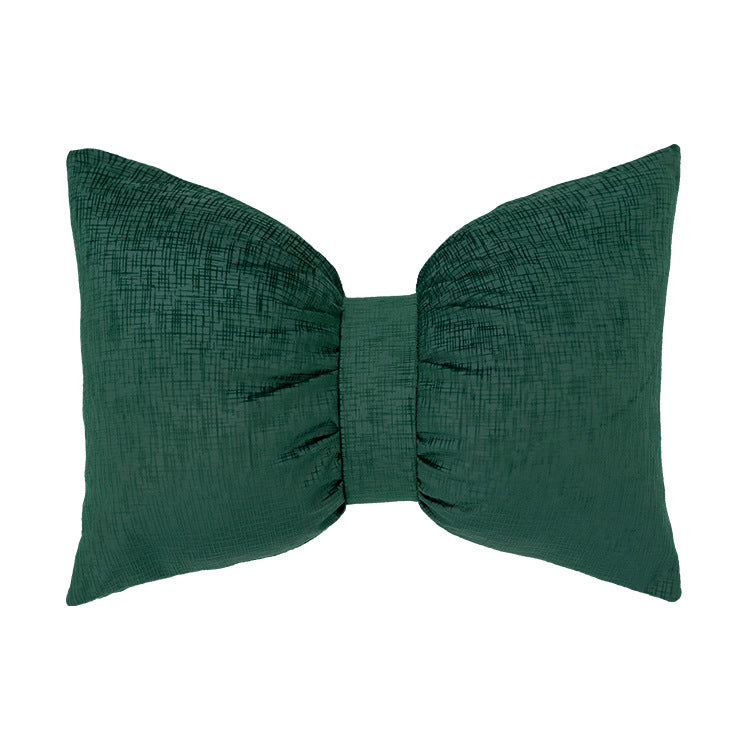 Bow-shaped decorative cushion with central band detail and structured fabric look