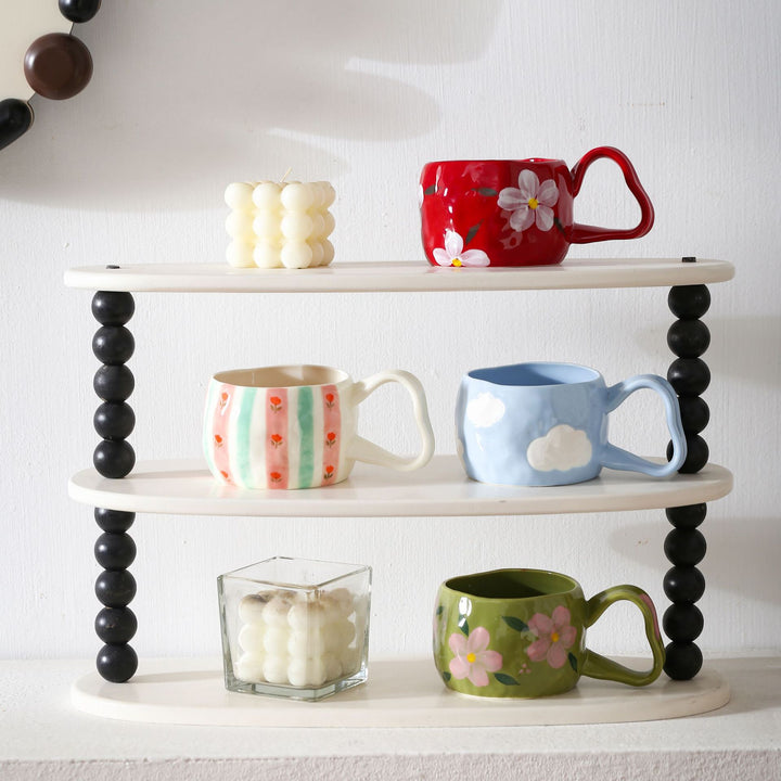 Ceramic mug with hand-painted stripes and flower design