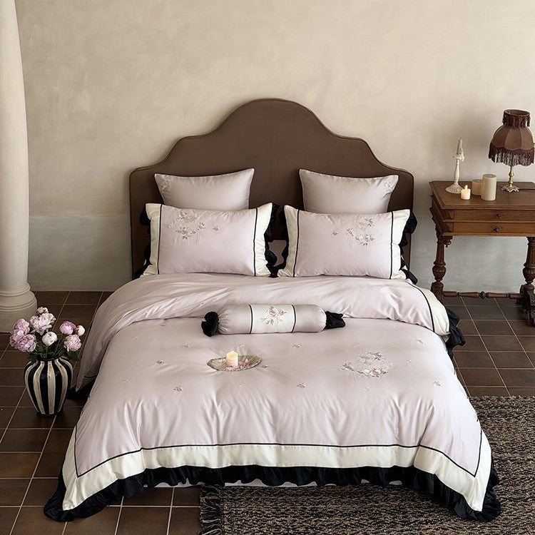 Elegant satin bedding set with floral embroidery relief look, ruffle and contrasting piping seam